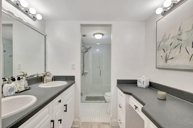 bathroom with vanity, tile patterned floors, toilet, and walk in shower