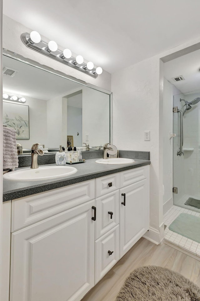 bathroom featuring vanity and a shower with shower door