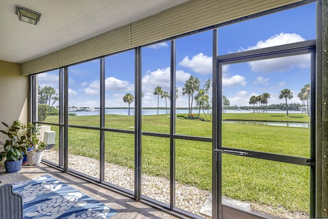 sunroom featuring a water view