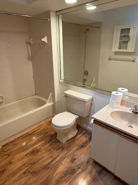 full bathroom featuring hardwood / wood-style floors, vanity, toilet, and tiled shower / bath