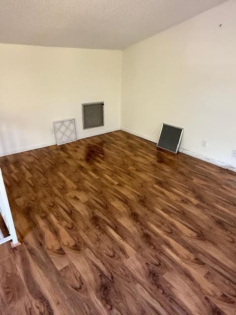 interior space featuring a textured ceiling and dark wood-type flooring