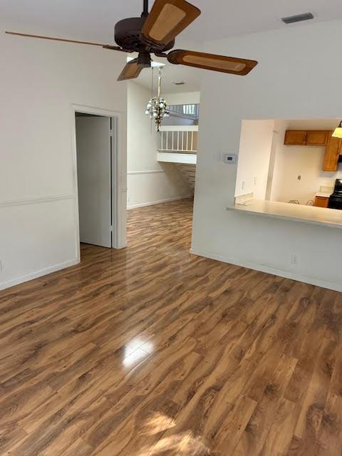 unfurnished living room with dark hardwood / wood-style floors and ceiling fan