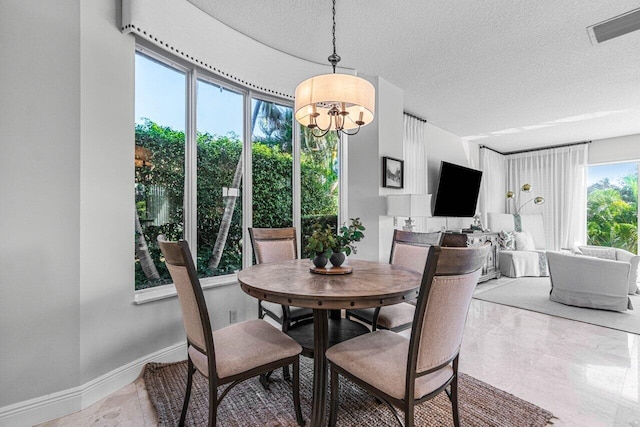 dining space with a textured ceiling and a notable chandelier