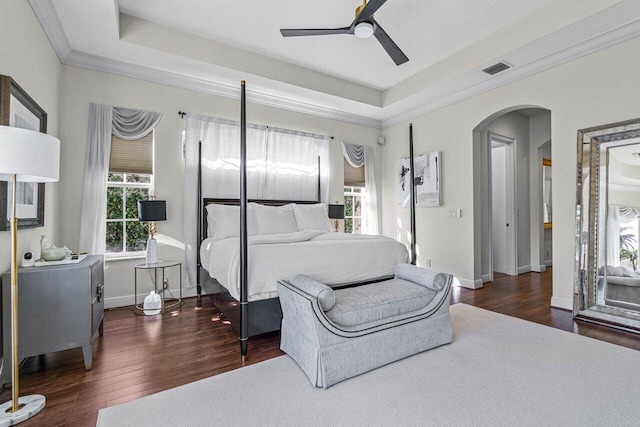 bedroom featuring crown molding, ceiling fan, dark hardwood / wood-style flooring, and a raised ceiling