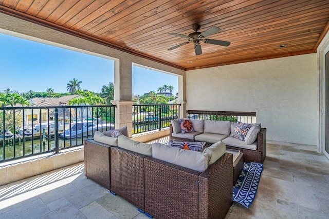 view of patio with a water view, ceiling fan, an outdoor living space, and a balcony