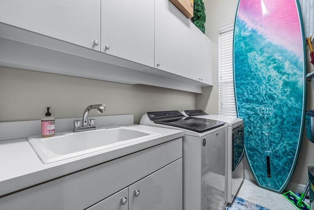 laundry room with cabinets, sink, and washing machine and dryer