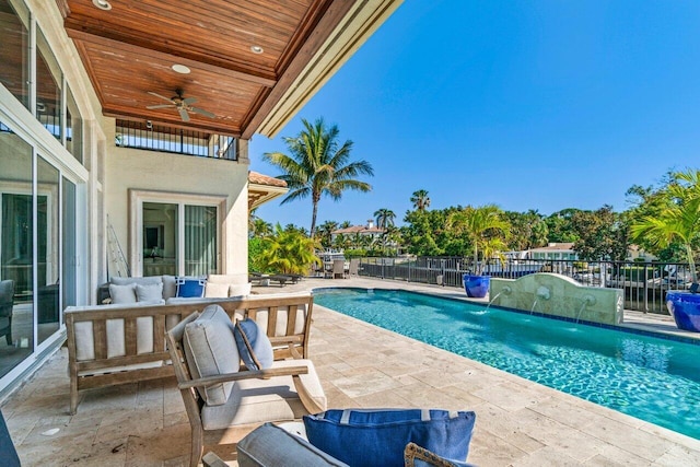 view of pool with pool water feature, ceiling fan, outdoor lounge area, and a patio