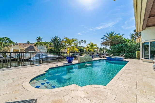 view of pool with an in ground hot tub, a water view, a patio area, and pool water feature