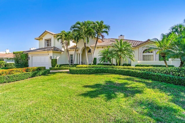 mediterranean / spanish home featuring a garage and a front yard