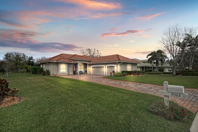 view of front of house featuring a garage and a lawn