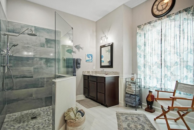 bathroom with a tile shower and vanity