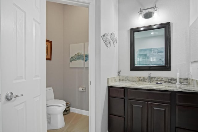 bathroom featuring vanity, toilet, and hardwood / wood-style floors