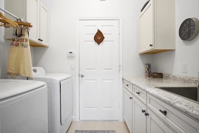 clothes washing area featuring washer and dryer, light tile patterned floors, sink, and cabinets