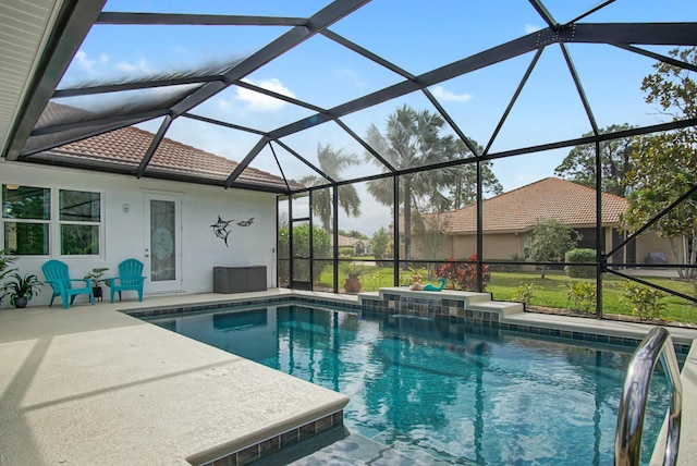 view of pool featuring pool water feature, glass enclosure, and a patio area