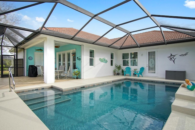 back of property with ceiling fan, a patio, and glass enclosure