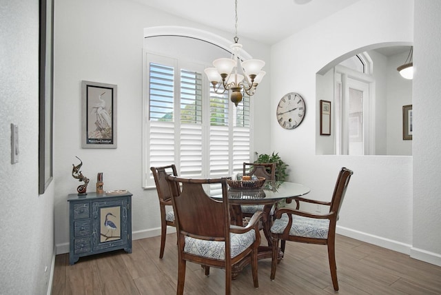 dining room featuring dark hardwood / wood-style flooring and a notable chandelier