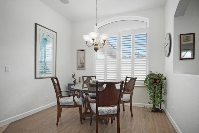 dining area with hardwood / wood-style flooring and a chandelier