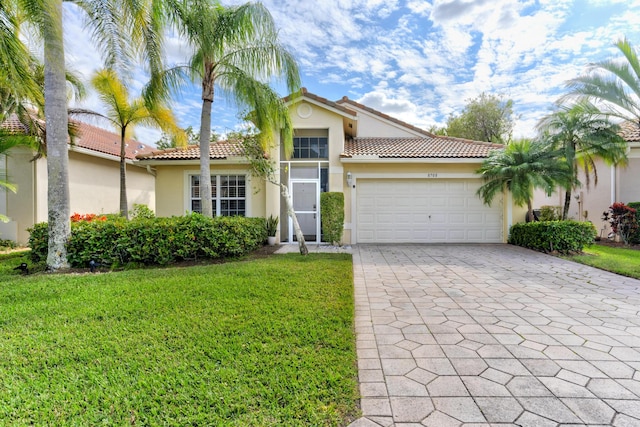 mediterranean / spanish home with a garage and a front yard