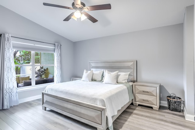 bedroom with vaulted ceiling, ceiling fan, and light wood-type flooring