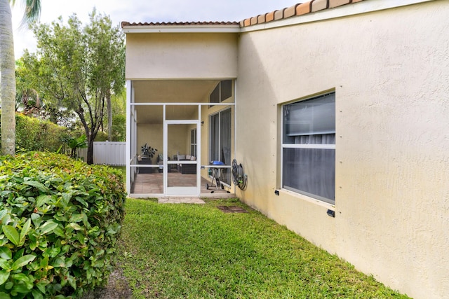 rear view of property with a yard and a sunroom