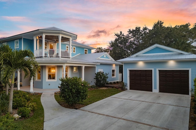 view of front of house with a garage, driveway, a porch, and a balcony