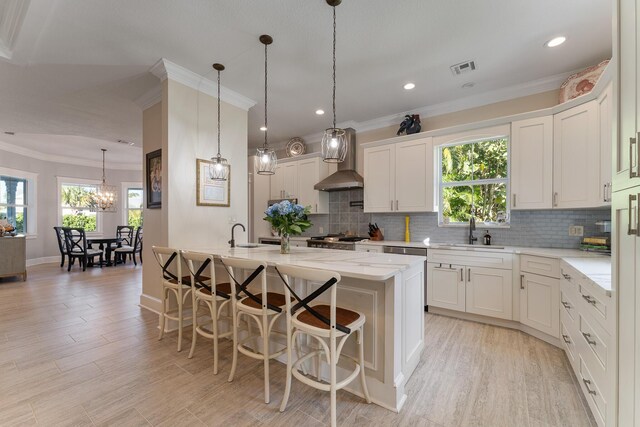 dining space featuring ornamental molding, plenty of natural light, a chandelier, and light hardwood / wood-style flooring