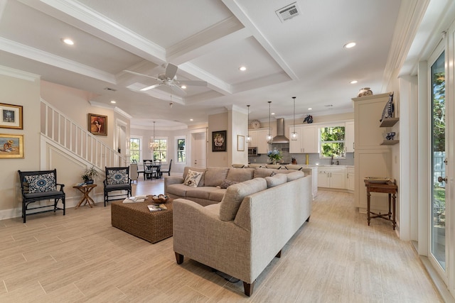 living room featuring light wood finished floors, beam ceiling, coffered ceiling, and visible vents