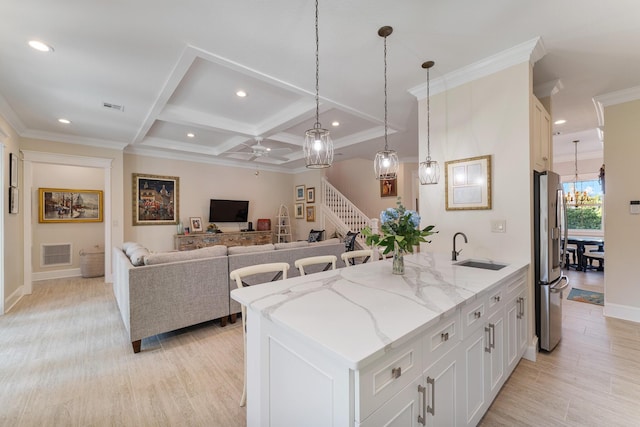 kitchen with coffered ceiling, visible vents, stainless steel refrigerator with ice dispenser, and a sink