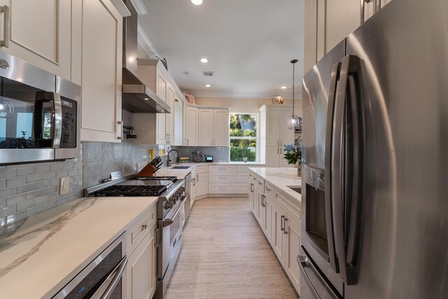 kitchen featuring pendant lighting, sink, stainless steel fridge, light stone countertops, and white cabinets