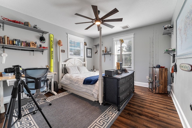 bedroom featuring a ceiling fan, wood finished floors, visible vents, and baseboards