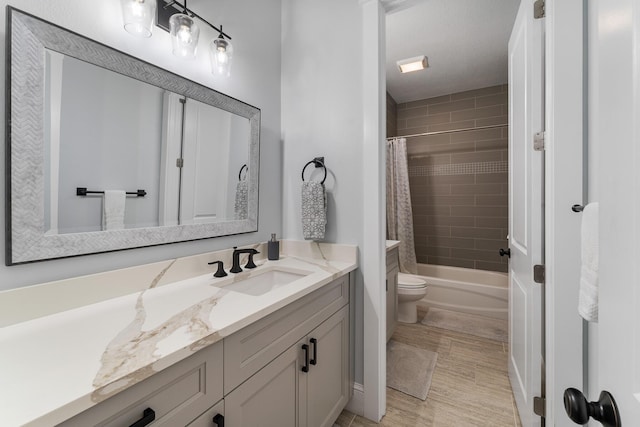 bathroom featuring toilet, shower / bath combination with curtain, and vanity
