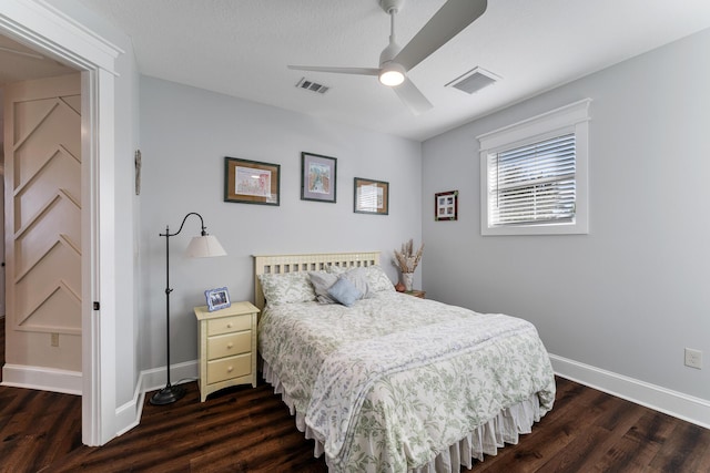 bedroom featuring dark wood-type flooring, ceiling fan, and a textured ceiling