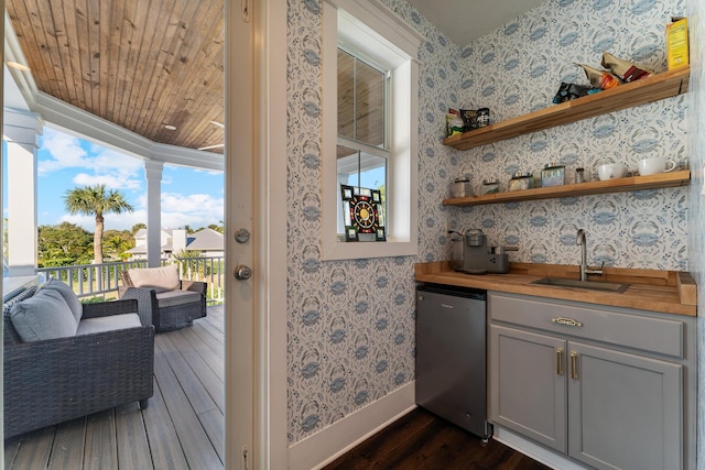 bar featuring sink, wooden counters, refrigerator, gray cabinetry, and a wealth of natural light