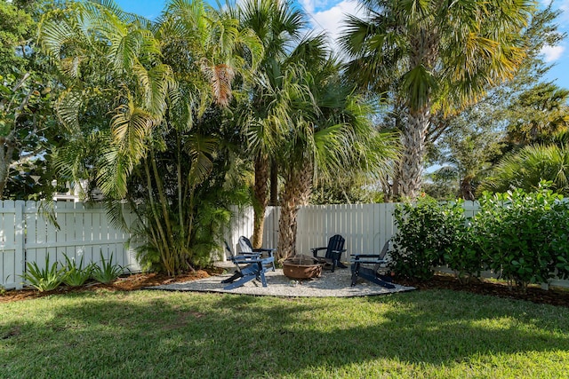 view of yard featuring a fenced backyard, a patio, and a fire pit
