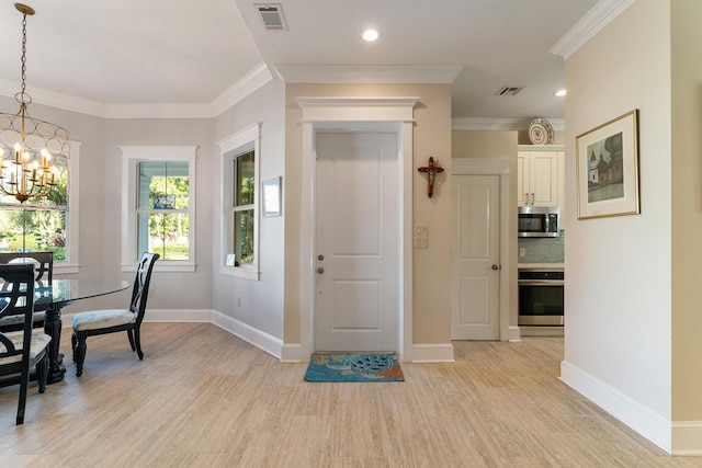 entryway featuring a notable chandelier, crown molding, and light hardwood / wood-style flooring