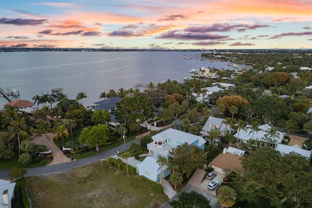 aerial view at dusk featuring a water view