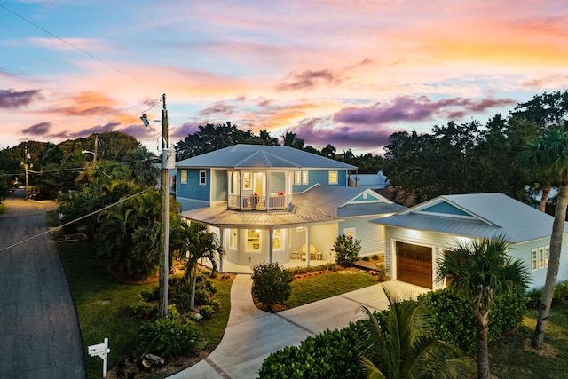 view of front of home featuring driveway, a balcony, and an attached garage