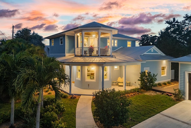 view of front of home with a balcony, metal roof, and a porch