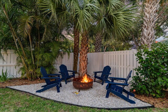 back house at dusk featuring a yard, a patio, and an outdoor fire pit