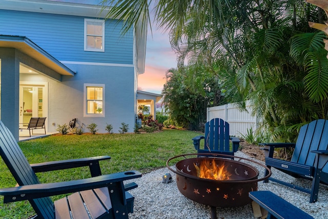 view of yard featuring an outdoor fire pit and fence