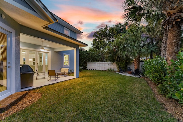 yard at dusk featuring a patio and french doors