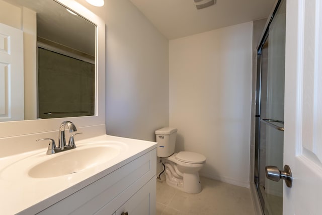 bathroom featuring vanity, toilet, a shower with shower door, and tile patterned flooring