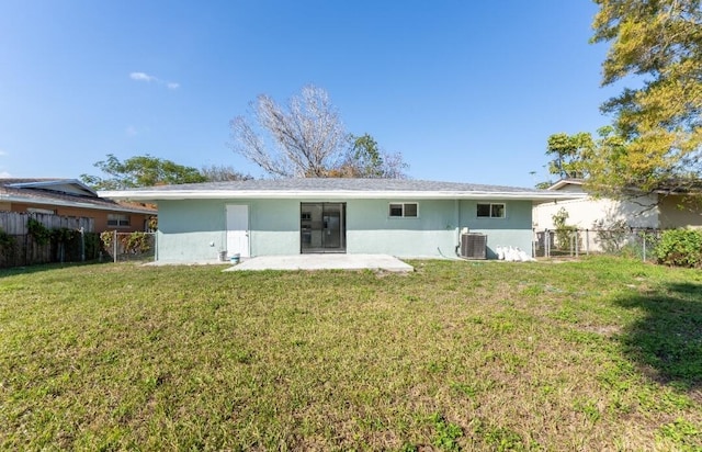 back of house featuring a yard, central AC unit, and a patio