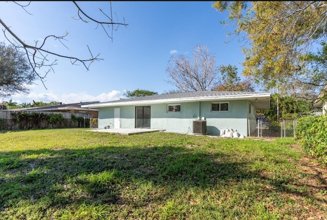 back of property with cooling unit and a lawn