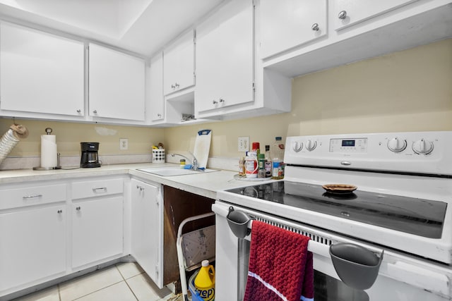 kitchen with sink, light tile patterned floors, white cabinets, and electric stove