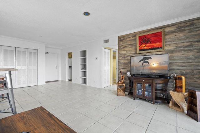 living room featuring light tile patterned flooring, ornamental molding, and built in features