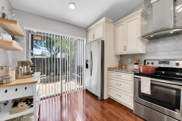 kitchen featuring wall chimney range hood, stainless steel appliances, dark hardwood / wood-style floors, cream cabinets, and light stone countertops