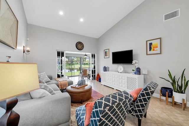 living room with light tile patterned floors and high vaulted ceiling