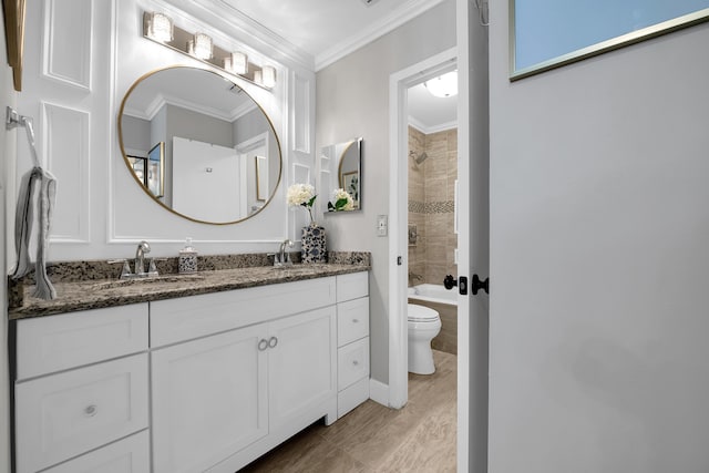 full bathroom with toilet, crown molding, tiled shower / bath, vanity, and hardwood / wood-style flooring