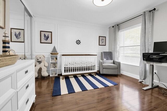 bedroom featuring crown molding and dark wood-type flooring